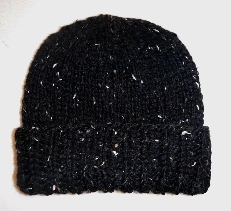 Puede incluir: Un gorro negro tejido con motas blancas. El gorro tiene un borde acanalado y un dise&ntilde;o cl&aacute;sico y ajustado. Este c&aacute;lido gorro de invierno es ideal para el clima fr&iacute;o.
