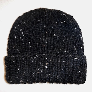 Puede incluir: Un gorro negro tejido con motas blancas. El gorro tiene un borde acanalado y una corona redondeada. Este c&aacute;lido gorro de invierno es ideal para el fr&iacute;o y mide aproximadamente 20 cm de altura.