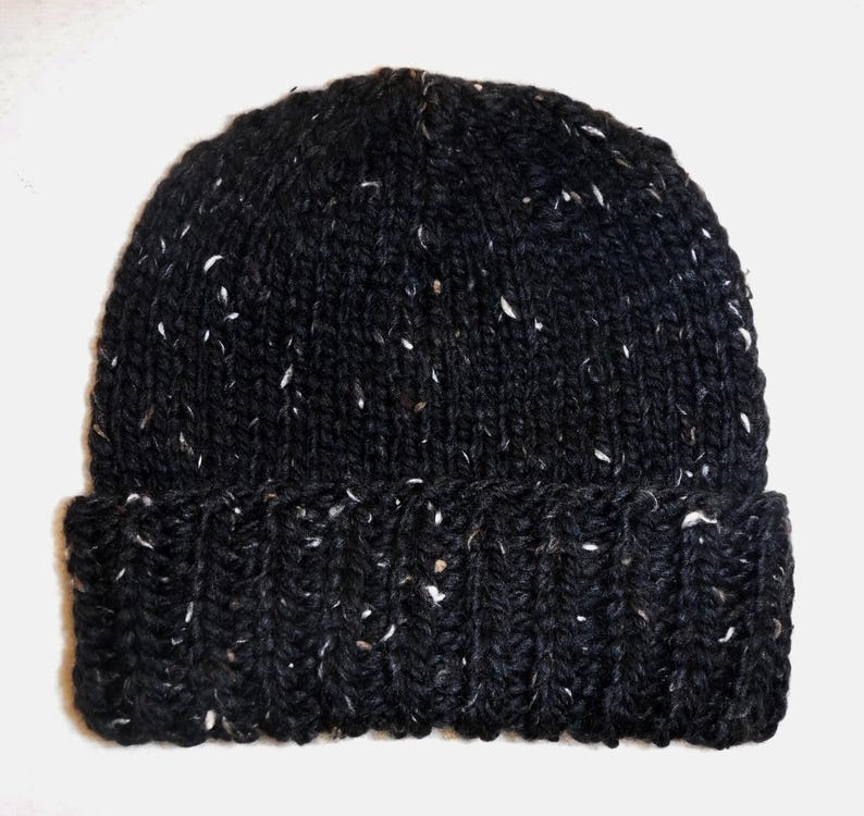 Puede incluir: Un gorro negro tejido con motas blancas. El gorro tiene un borde acanalado y una corona redondeada. Este c&aacute;lido gorro de invierno es ideal para el fr&iacute;o y mide aproximadamente 20 cm de altura.