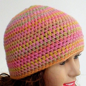 May include: A crocheted hat in shades of pink, orange, yellow, and green. The hat has a simple design and is made with a soft yarn.
