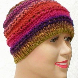 May include: A colorful knitted hat with a multi-colored striped pattern in shades of orange, pink, purple, and green.