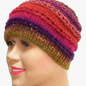 May include: A multi-colored knitted beanie hat with a textured pattern. The hat is made with a gradient of colors, including red, orange, yellow, green, purple, and blue.