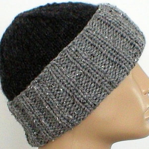 May include: A black and grey knitted beanie hat with a slouchy fit. The hat is made from a soft, warm yarn and has a unique two-tone design.