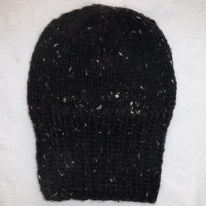Puede incluir: Un gorro negro tejido con motas blancas. El gorro est&aacute; hecho de un hilo grueso y texturizado y tiene un borde acanalado. El gorro es un estilo cl&aacute;sico, adecuado para el clima fr&iacute;o.