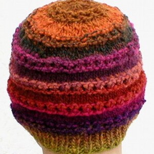 May include: A colorful knitted hat with stripes of orange, red, pink, purple, green, and brown.