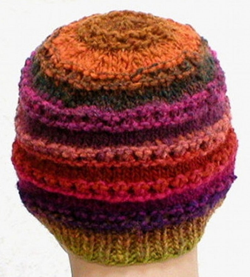 May include: A colorful knitted hat with stripes of orange, red, pink, purple, green, and brown.
