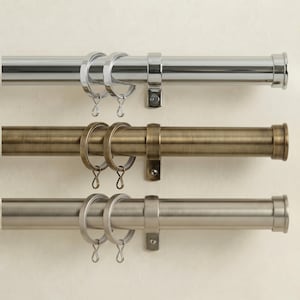 May include: Three curtain rods in polished chrome, antique brass, and brushed nickel finishes. Each rod has matching rings and mounting hardware. These rods are designed for hanging curtains and drapes, providing a decorative and functional window treatment solution.