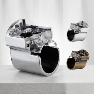 May include: A chrome faucet with a cutaway section showing the internal workings. Two other faucets are shown, one chrome and one bronze. The cutaway reveals the internal mechanisms, showcasing the faucet's design and functionality.