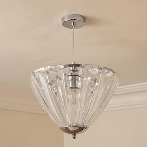 May include: A ceiling pendant light fitting featuring a chrome finish canopy and a bowl-shaped shade constructed from multiple clear, vertical glass panels. The light is suspended by a white cord and includes a central chrome finial at the bottom.