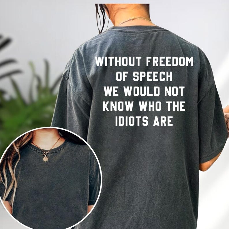 a person wearing a grey t-shirt with the text "Without freedom of speech we would not know who the Idiots are" printed on the back.