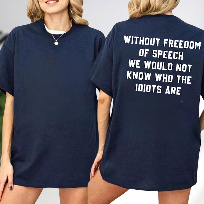 a woman wearing a navy blue t-shirt with the text "Without freedom of speech we would not know who the Idiots are" printed on the back.