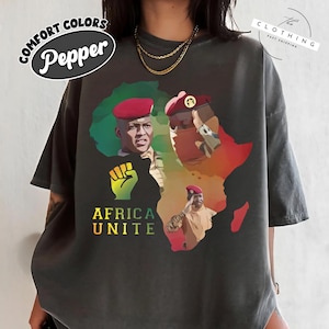 a woman wearing a black t - shirt with a picture of a man in africa