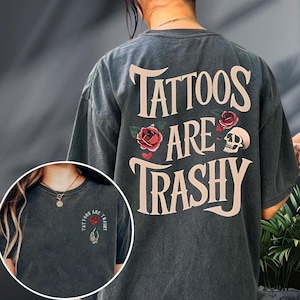 A person wearing a gray t-shirt with the text "Tattoos are Trashy" printed on it.