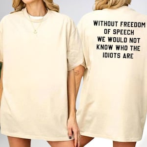 a person wearing a white t-shirt with the text "Without freedom of speech we would not know who the idiots are" printed on the back.