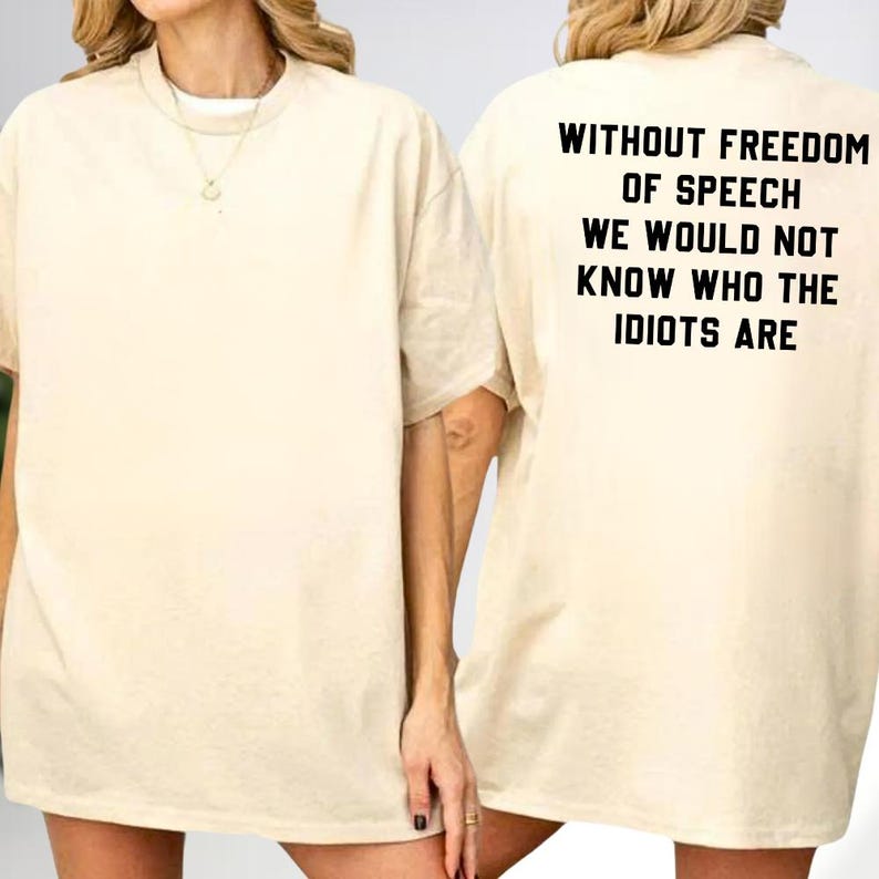a person wearing a white t-shirt with the text "Without freedom of speech we would not know who the idiots are" printed on the back.