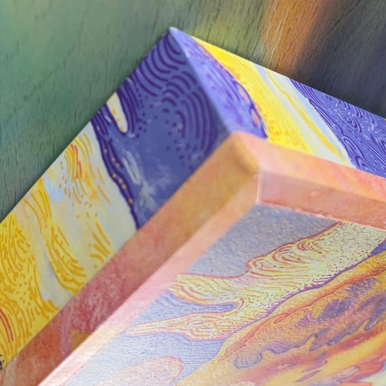 May include: A corner view of a rectangular canvas featuring an abstract design with textured, swirling patterns in shades of purple, yellow, and orange. The canvas edges are wrapped in the same colorful, textured print, showing a thick profile.