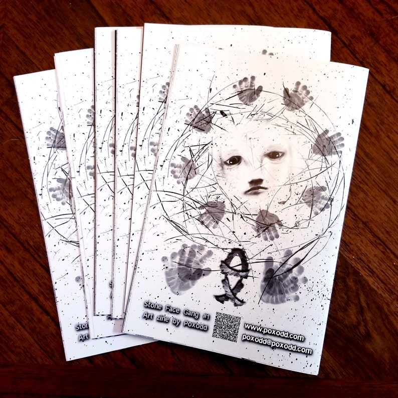 May include: A stack of black and white art zines with a handprint design and the text "Stone Face Gang #1 Art zine by Poxodd" on the front cover. The zines also include the website address "www.poxodd.com" and an email address.