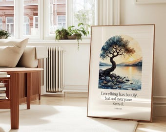 May include: A framed art print featuring a watercolor painting of a tree by a lake at sunset. The artwork includes the quote, "Everything has beauty, but not everyone sees it." The print is displayed in a living room setting.