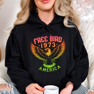 May include: A black hoodie with a colorful eagle graphic and the text "Free Bird *1973* America".