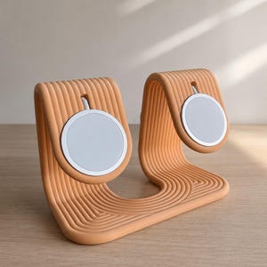 Peut inclure: Un support de charge pêche, nervuré, avec deux socles de chargement circulaires blancs. Le support a un design incurvé en forme de vague et est fait d'un matériau solide. Le support est conçu pour maintenir et charger des appareils électroniques.