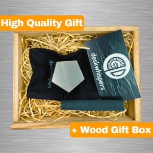 Könnte beinhalten: Eine Holzschenkbox mit einem schwarzen Beutel, der ein silbernes sechseckiges Fidget-Spielzeug enthält. Die Box hat ein schwarzes Etikett mit dem Text "deskwhispers" und einem Logo. Der Text "High Quality Gift" befindet sich in einem gelben Banner über der Box. Der Text " + Wood Gift Box" befindet sich in einem gelben Banner unter der Box.