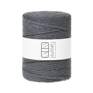 May include: A spool of gray macrame cord with a white label wrapped around it. The label features a geometric design and the word "outlet". The cord is tightly wound, and the overall appearance is neat and organized.