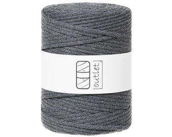 Puede incluir: Un carrete de hilo de macramé gris con una etiqueta blanca. La etiqueta presenta un diseño geométrico y la palabra "outlet". El hilo está bien enrollado, con un aspecto limpio y organizado. Ideal para proyectos de manualidades.