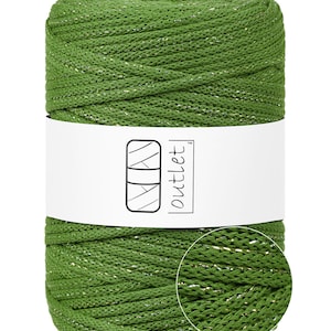 May include: A spool of green yarn with a subtle metallic sheen. The yarn is wrapped around itself, forming a cylindrical shape. A white label with the word "outlet" is wrapped around the yarn.