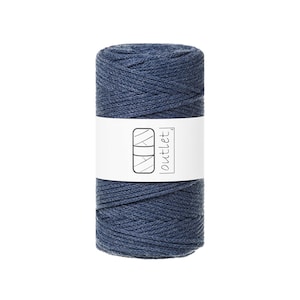 May include: A tightly wound spool of navy blue yarn. A white label wraps around the center, displaying a logo and the word "outlet". The yarn appears to be made of a soft, textured material, suitable for various crafting projects.