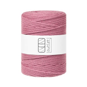Può includere: Una bobina cilindrica di cordoncino macramè color rosa polveroso. Un'etichetta bianca avvolge il centro, mostrando un disegno a tratto di tre rettangoli impilati e la parola "outlet". Il cordoncino è avvolto strettamente, mostrando una superficie strutturata.