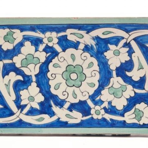 Carreau de style Iznik à décor floral, bordure d’arabesques de palmettes, du XIXe.