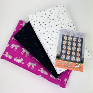 May include: A stack of three fabric squares in pink, black, and white with a white plus sign pattern. The fabric squares are accompanied by a card with the text "Paralleled Quilt" and "Running Doe Quilts for the modern maker".