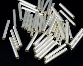 Può includere: Un mucchio di tubi metallici color argento, probabilmente utilizzati per la creazione di gioielli o artigianato.