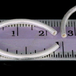 Puede incluir: Dos anillos de salto de plata, cada uno con un di&aacute;metro de aproximadamente 2,5 cm, se colocan sobre una regla. La regla muestra que los anillos son ligeramente m&aacute;s grandes que 2,5 cm.
