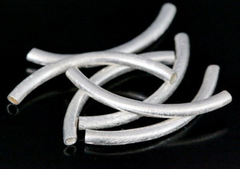 Puede incluir: Un conjunto de seis tapas de cuentas de metal plateadas, cada una con una forma curva. Las tapas est&aacute;n dise&ntilde;adas para ser utilizadas en la elaboraci&oacute;n de joyas.