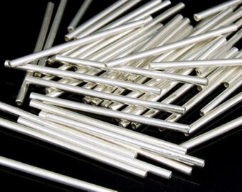 Può includere: Un mucchio di aste metalliche di colore argento, di circa 2,5 cm di diametro e 5 cm di lunghezza.