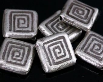 May include: A group of six silver square beads with a spiral design. The beads are about 1 inch in size.