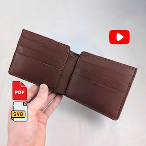 May include: A brown leather bifold wallet featuring multiple interior card slots on both sides with visible stitching along the edges. The wallet is open to display the internal compartments, showcasing a smooth, matte finish and a structured design.