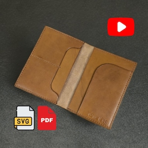 May include: Open, brown leather passport holder with multiple pockets. The interior is a lighter tan color. The holder is on a dark gray surface. The image also includes SVG and PDF icons, and a YouTube play button.