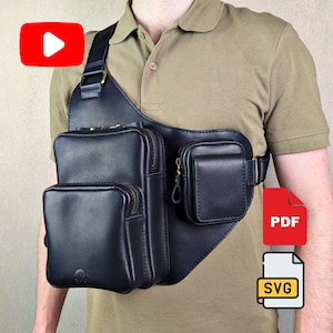 May include: A black leather chest bag featuring a large main compartment with a zipper closure, a smaller front pocket, and an additional side pouch. The bag is secured with a wide shoulder strap and includes metallic hardware accents throughout.