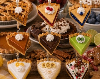 Peut inclure: Une collection de neuf ornements miniatures en forme de parts de tarte suspendus par de la ficelle de jute, incluant des saveurs variées comme pomme, cerise, myrtille, citrouille, chocolat, citron vert, citron, banane et une part au chocolat décorée.