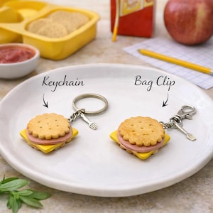 May include: A white ceramic mug with a black handle and the text "But First, Coffee" in a bold, black font. The mug is set against a blurred background, highlighting its simple design.