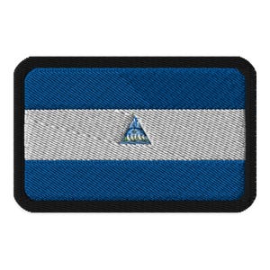 May include: A blue, white, and blue embroidered patch with the flag of Nicaragua. The patch has a black border.
