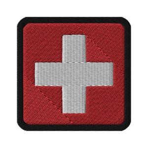Puede incluir: Un parche cuadrado rojo con una cruz blanca en el centro. El parche tiene un borde negro.