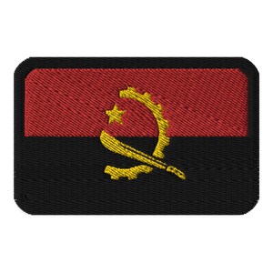 May include: Embroidered patch featuring the flag of Angola. The design includes a red upper section, a black lower section, and a central emblem in yellow. The emblem consists of a star, a gear, and a machete.