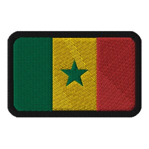 May include: A rectangular patch featuring the flag of Senegal. The flag is divided into three vertical stripes of green, yellow, and red. A green star is centered on the yellow stripe. The patch has a black border.