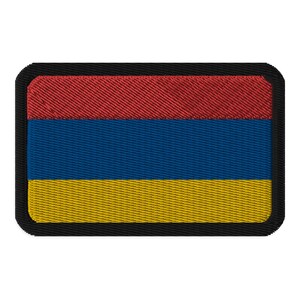 May include: Embroidered patch featuring the Armenian flag. The rectangular patch has a black border and displays the flag's horizontal stripes: red at the top, blue in the middle, and yellow at the bottom. The fabric has a textured appearance.
