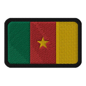 May include: A rectangular embroidered patch with the flag of Cameroon. The flag is green, red, and yellow with a yellow star in the center of the red stripe.