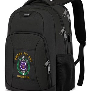 May include: Black backpack with multiple zippered compartments and a top handle. The front pocket features the Omega Psi Phi Fraternity Inc. emblem in purple, gold, and green. The backpack has adjustable shoulder straps and a side mesh pocket.
