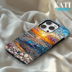 May include: A black phone case with a stained glass design featuring a beach scene with seashells, waves, and a sunset. The case has the text "KATI TRENDS" in white and turquoise.